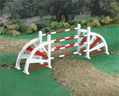 Oxers are a set of fences placed several feet apart that give width to an obstacle, encouraging a greater effort from the horse. This wooden jump is painted in colorful red and white.