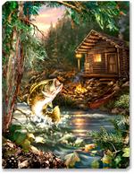 A large spotted bass leaps out of the mountainside creek to catch a dragonfly. A tiny log cabin sits in the background, complete with red canoe, stone fireplace, lantern, and campfire. The mountains behind the cabin are filled with lush evergreen trees.